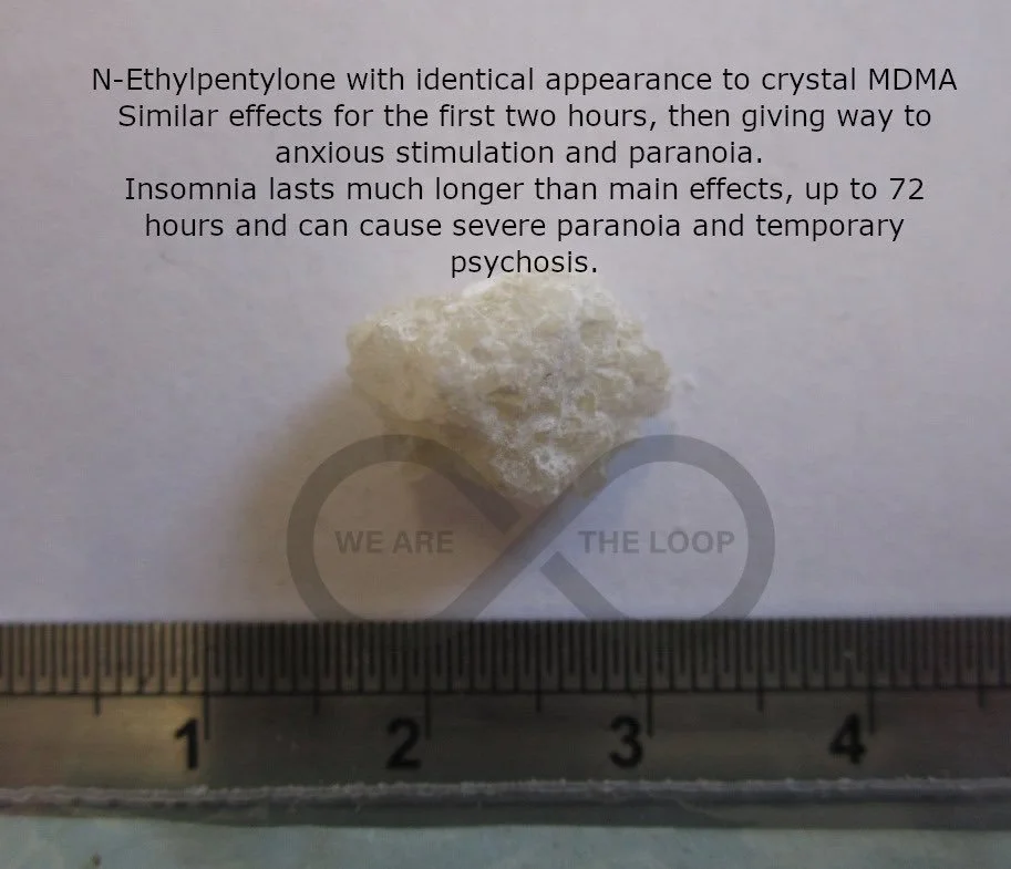 A small, irregularly shaped white crystalline substance on a sheet of paper with printed text explaining its effects and duration, placed above a ruler for scale.