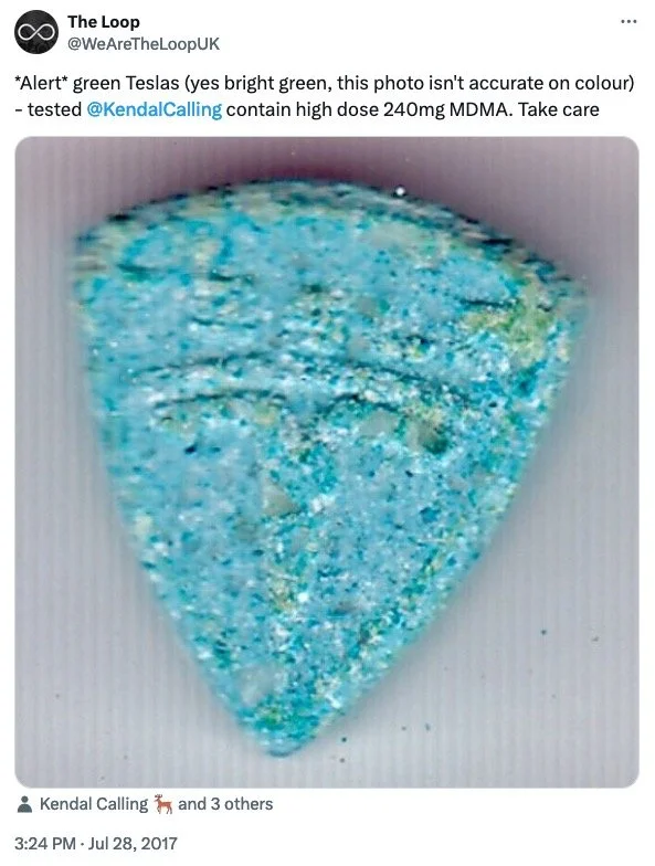 Close-up photo of a sharp green Tesla key fob designed like a triangular shape with a textured surface in bright green color.