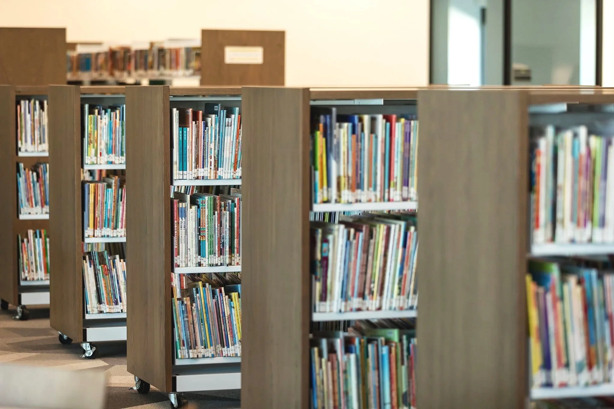 Bookshelves filled with colorful books in a library.