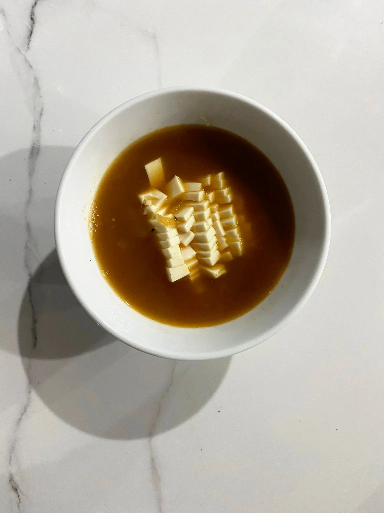A bowl of soft tofu in a miso broth