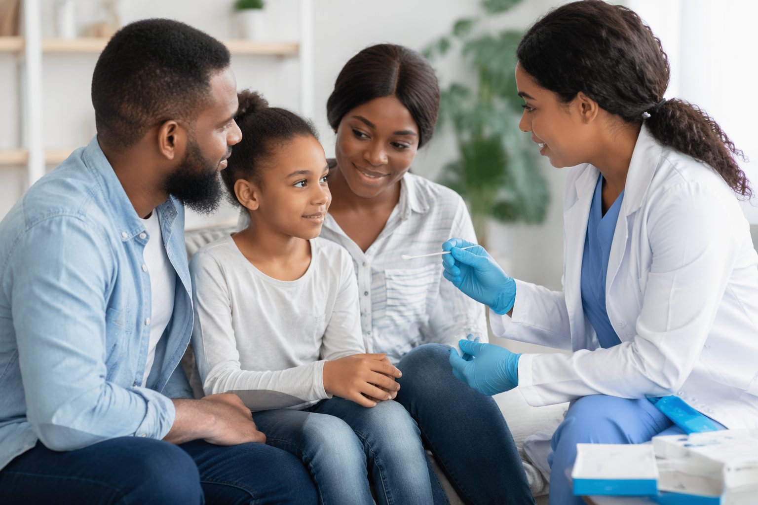 A healthcare professional prepares to administer a nasal swab test to a young girl, with her parents looking on in a brightly lit, modern medical office.