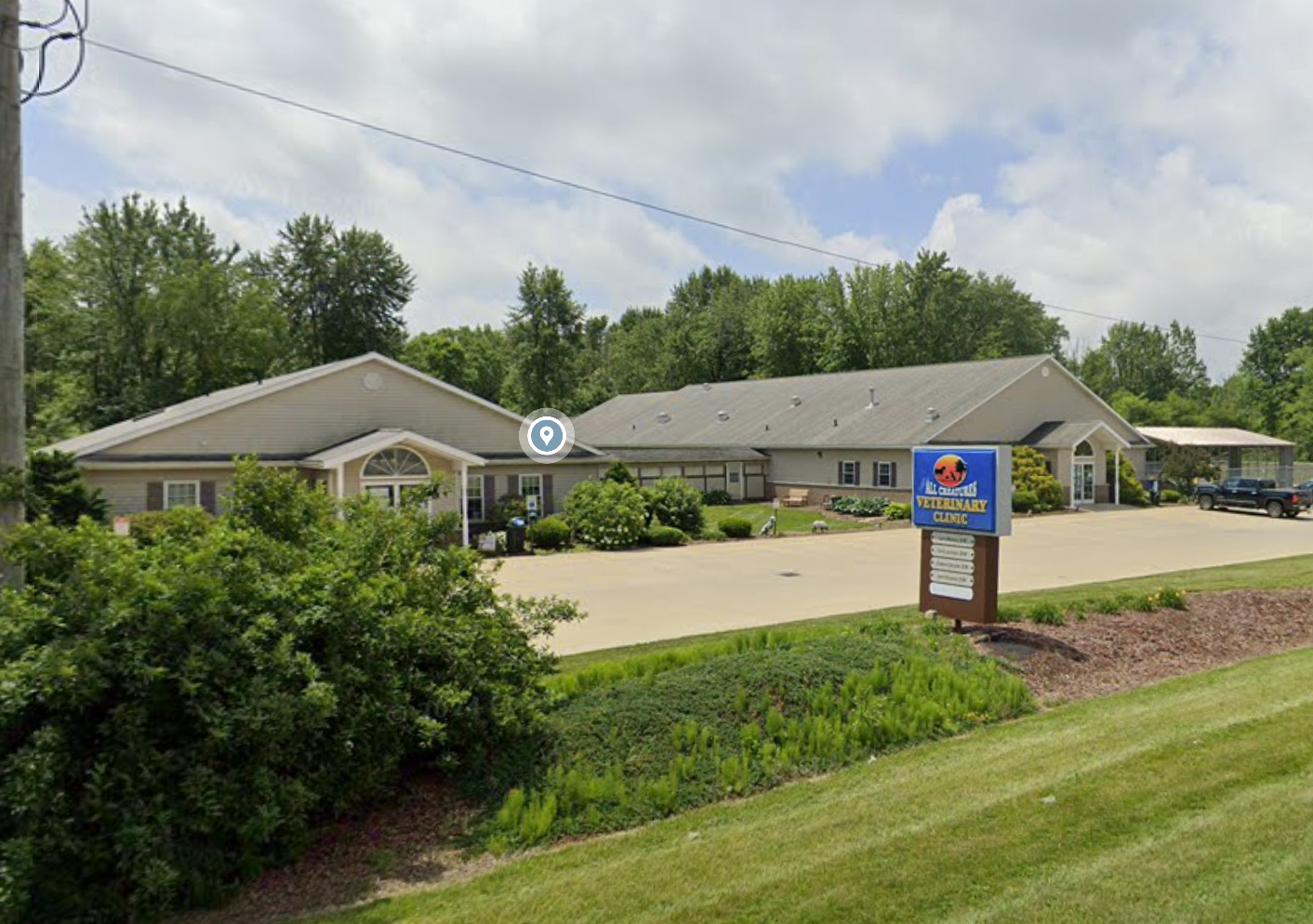 Exterior of All Creatures Veterinary Clinic and Lodge building in Rittman Ohio with signage and parking area