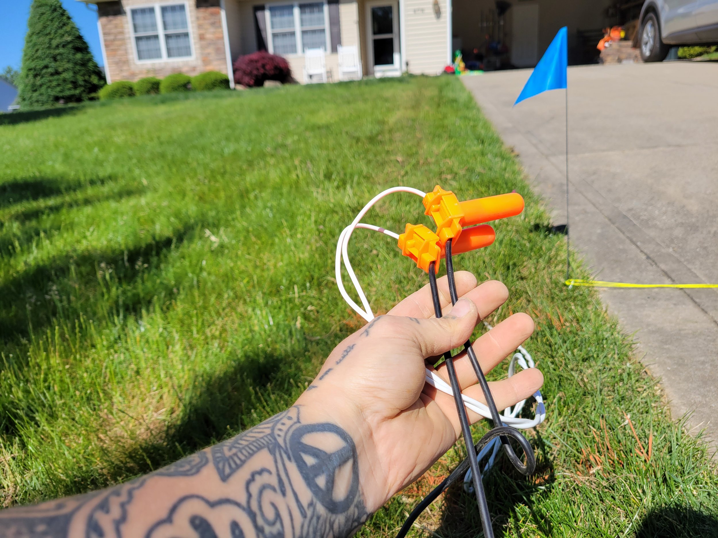 Underground dog fence wire and connectors being prepared for out of sight fencing installation in residential yard