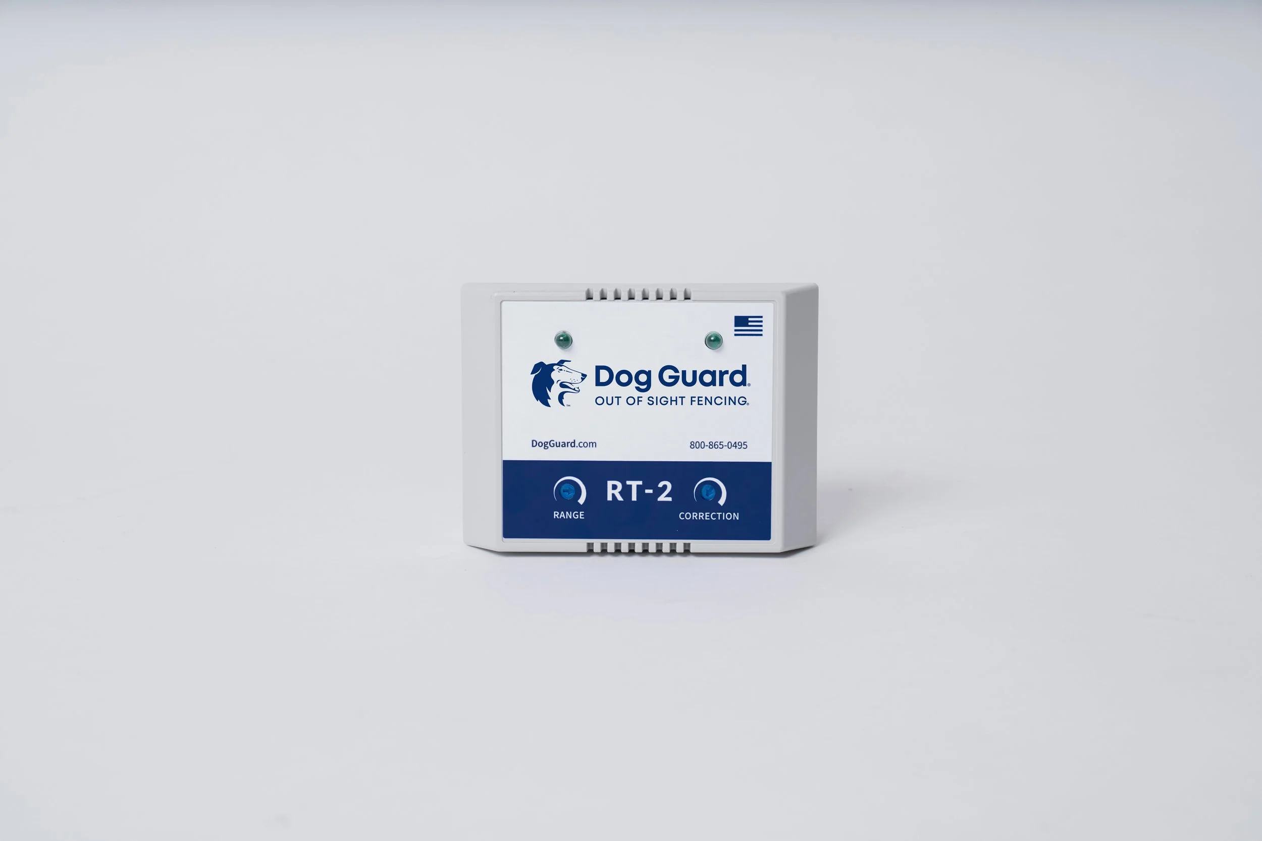 A Dog Guard RT-2 fence transmitter device with labels for range and correction, placed against a plain background.