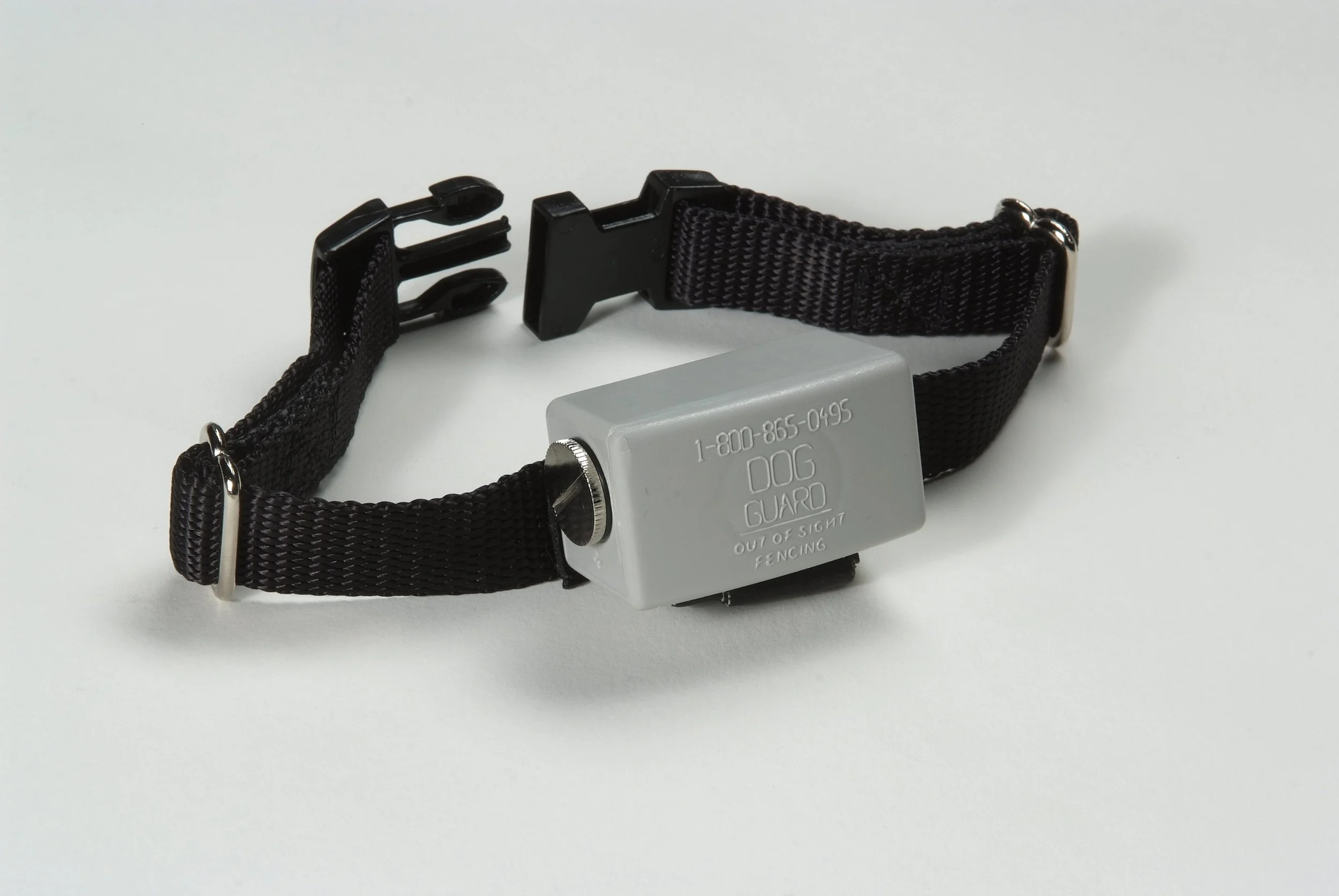 A black adjustable dog collar with a metal buckle and a gray tag attached, displaying a phone number and the words "Dog Guard".