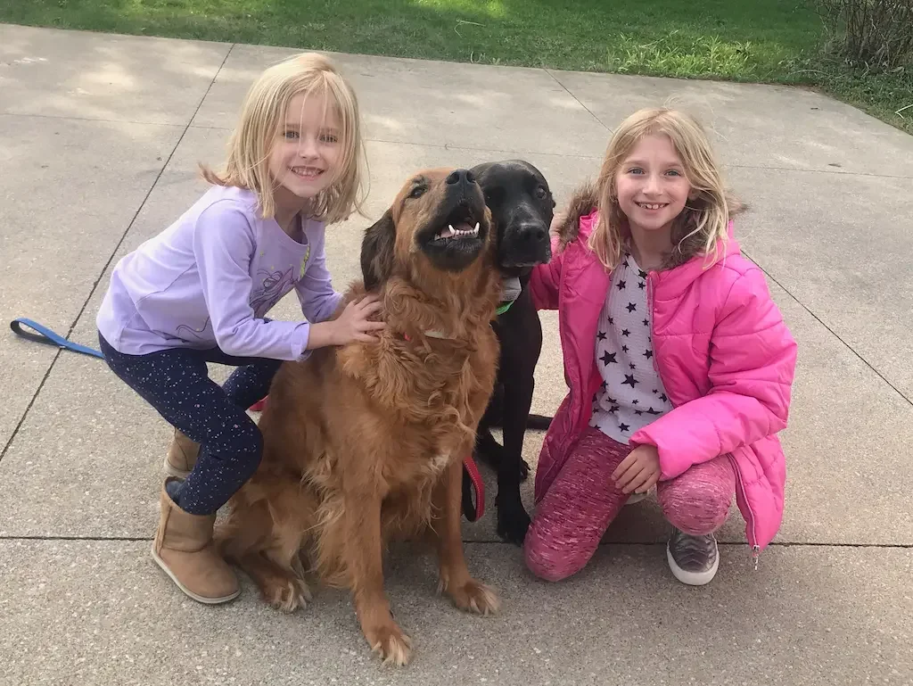 Family with children and dog enjoying backyard secured by underground dog fence