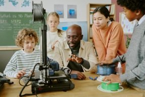 students watching a teacher operate a machine