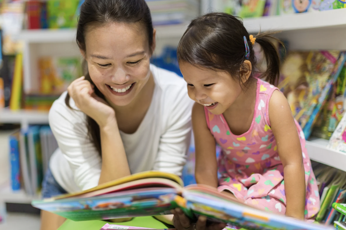 adult and child reading a book together