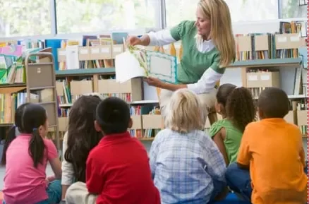 teacher reading a book to students