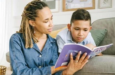 woman and boy reading a book together