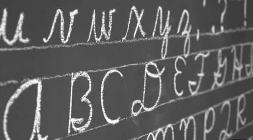 chalkboard showing letters written in cursive
