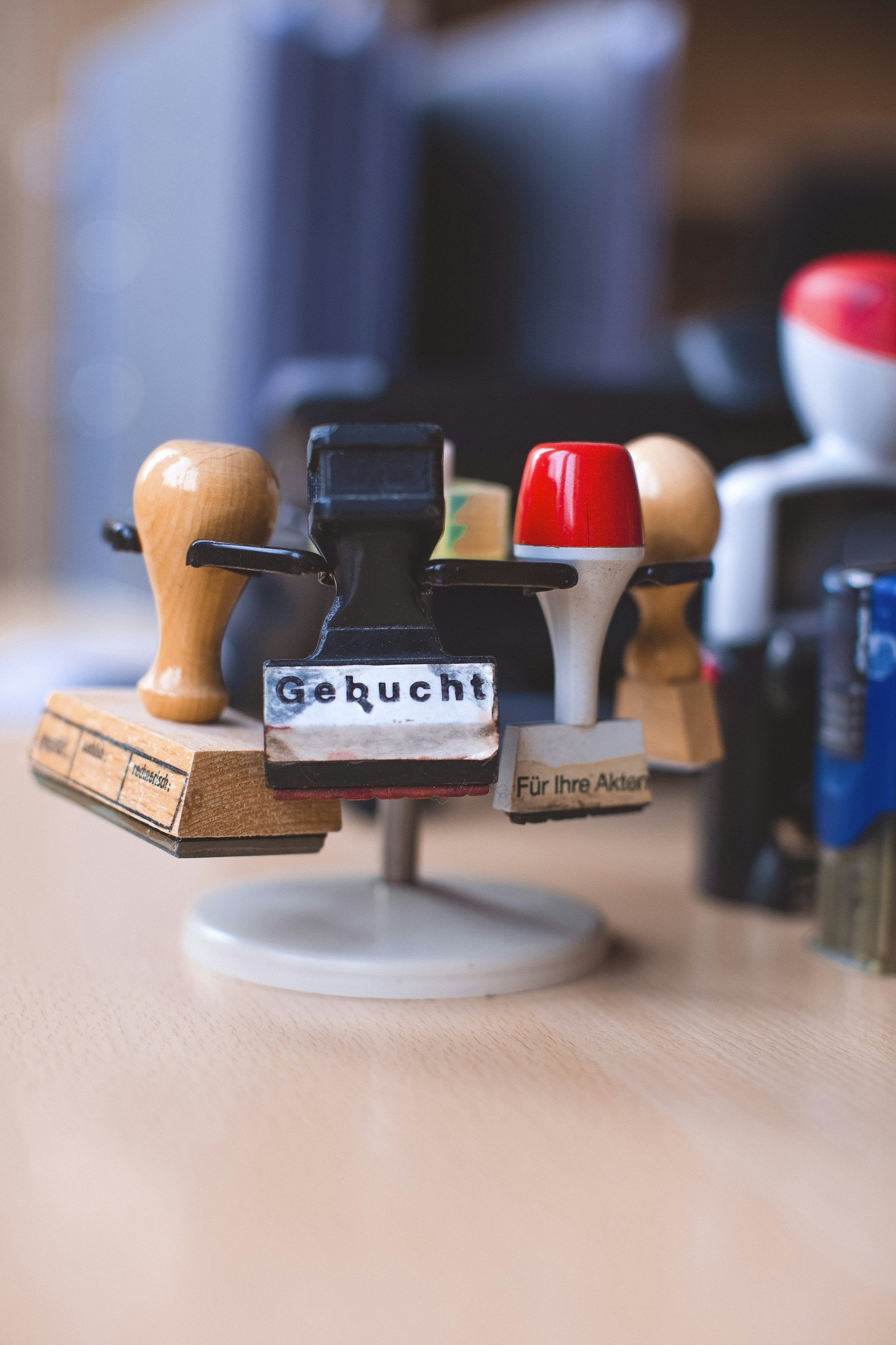 Close-up of a miniature wooden and plastic toy boat with various colored parts, with German labels, placed on a light surface.