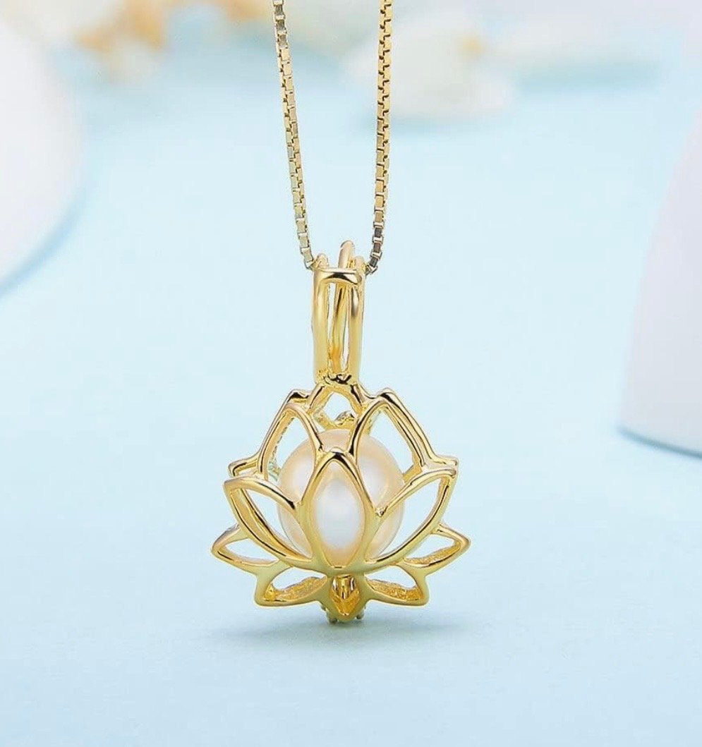Gold lotus-shaped pendant with a white pearl at the center, hanging on a gold chain.