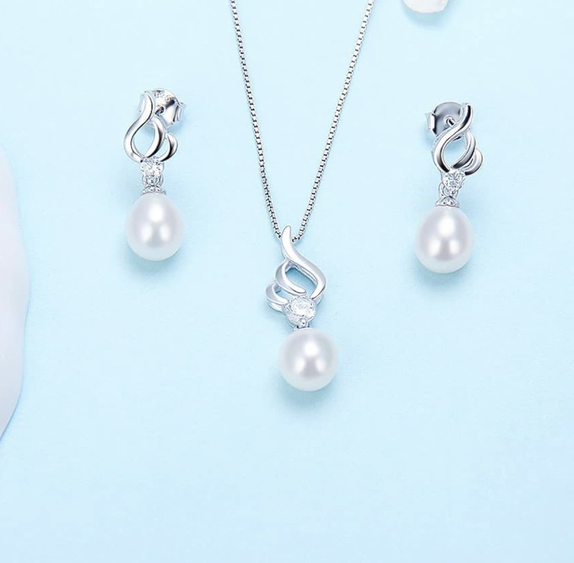 Silver pearl jewelry set including a necklace and matching earrings with white pearls and intricate silver designs.
