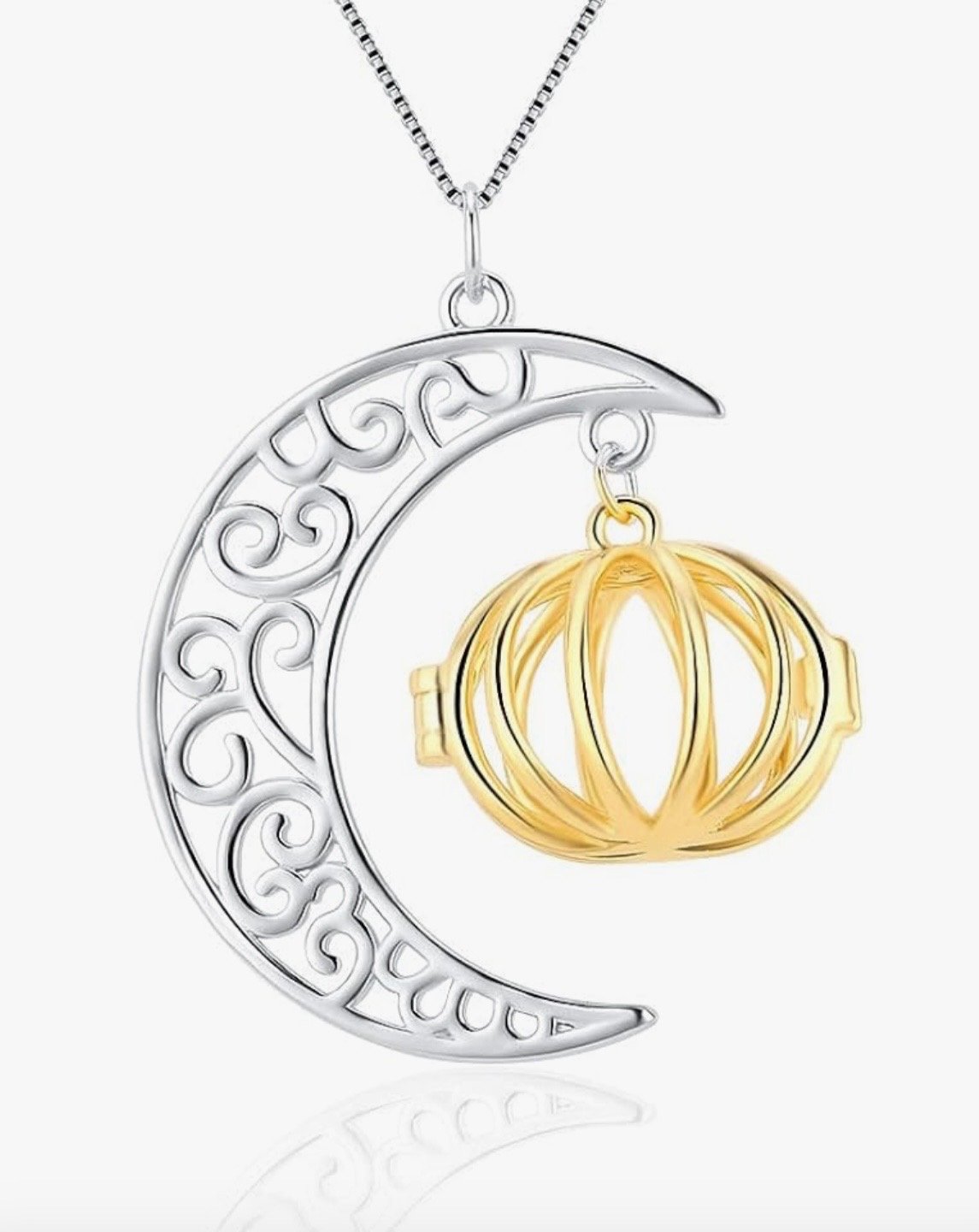 A silver pendant necklace featuring a crescent moon with decorative scrollwork and a gold pumpkin hanging from it.