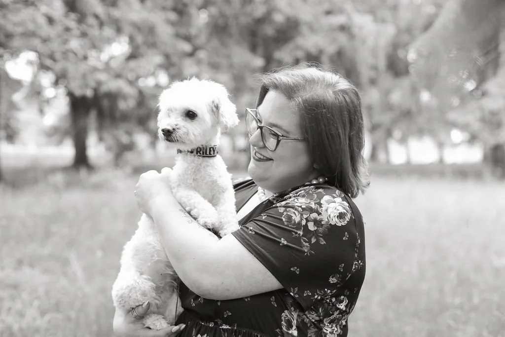 Jessica Allen, LCSW, C-AAIS, AAT-I holding her therapy dog Riley, gazing at her lovingly in Como Park located in Lancaster, New York.