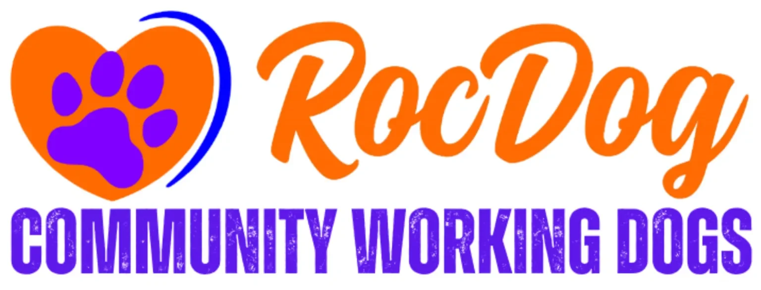Logo for RocDog Community Working Dogs featuring a purple paw print inside an orange heart and the text 'RocDog' in orange cursive and 'Community Working Dogs' in purple uppercase letters.