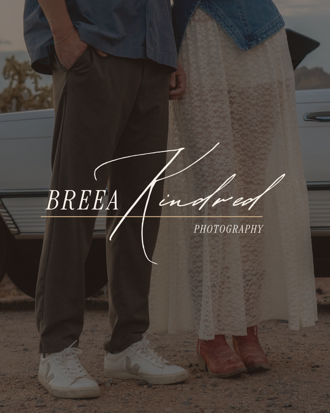 Close-up of two people standing outdoors near a vintage car, showing their lower bodies and footwear, with the text "Breea Kindred Photography" overlaid.