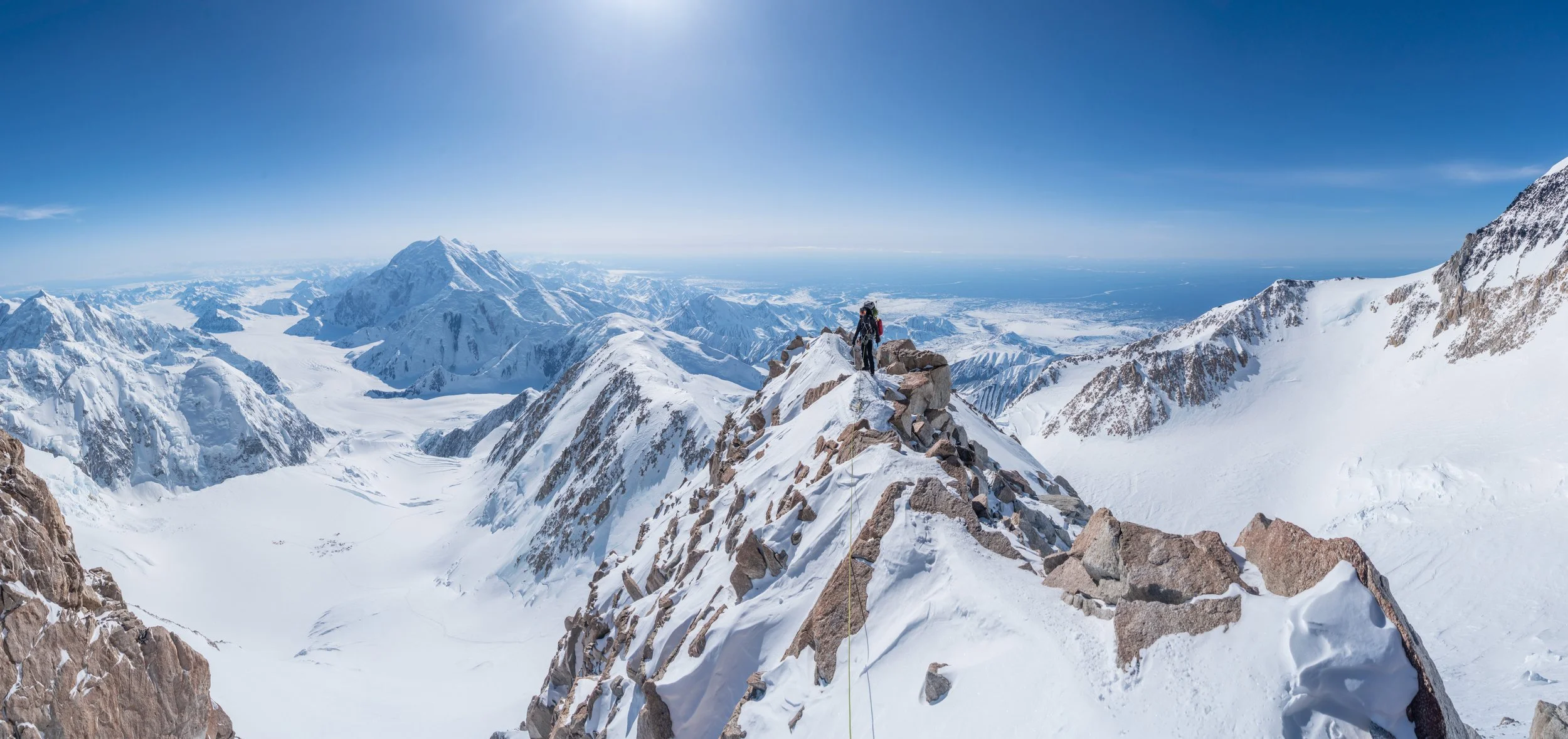 Sam on the 16k ridge with Foraker in the background, 14k camp bottom left.