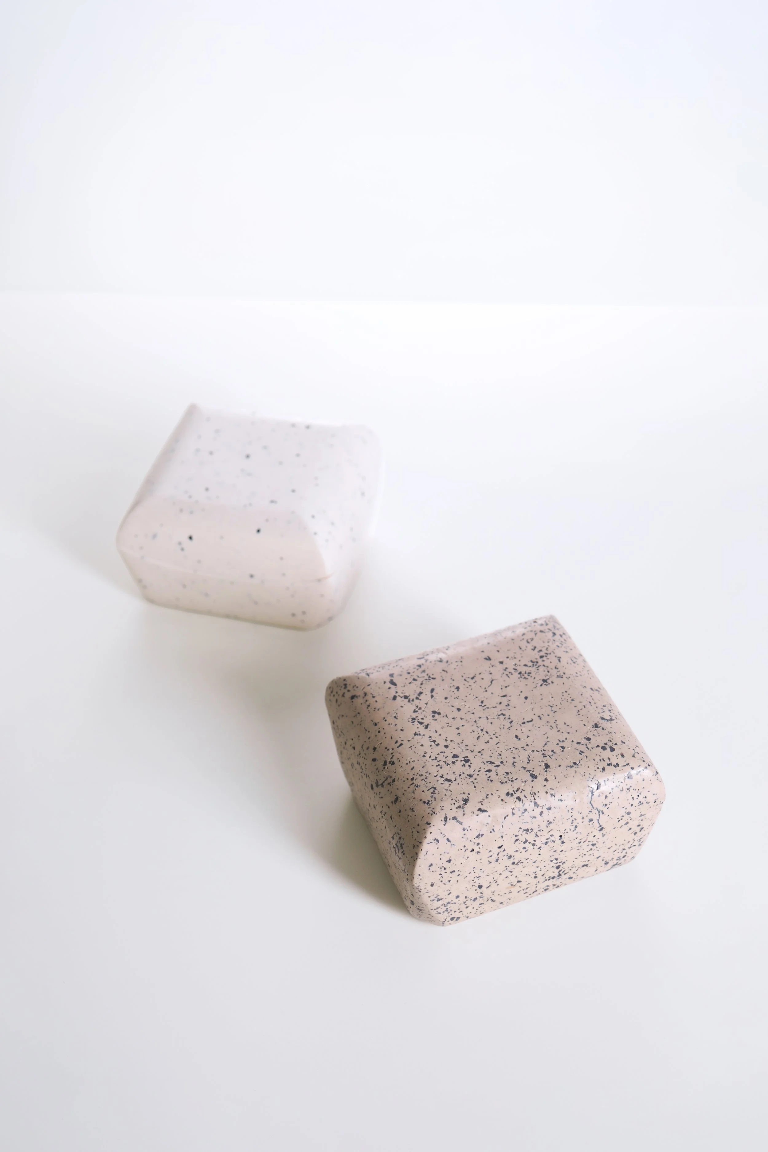 Three rectangular stones with speckled patterns on a white surface.