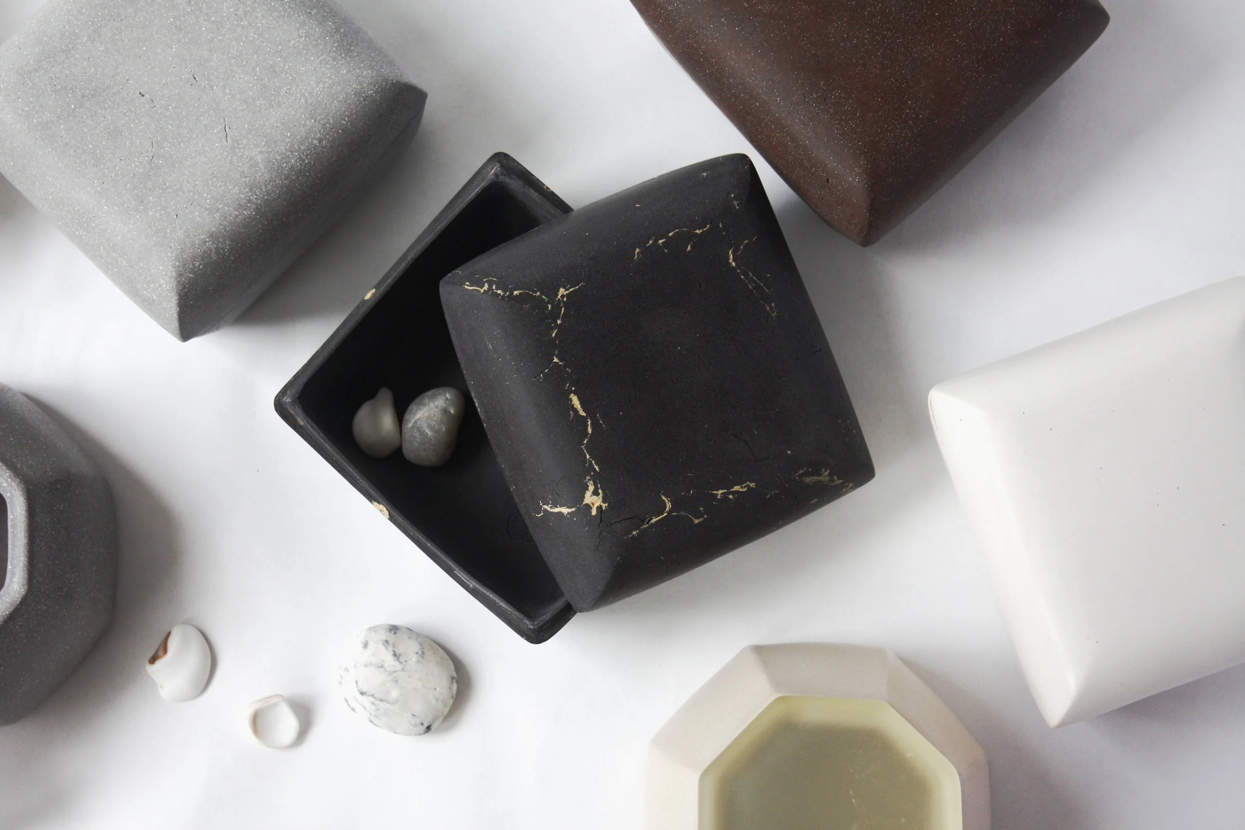Various geometric-shaped objects including cubes and rocks in different colors and textures on a white surface.