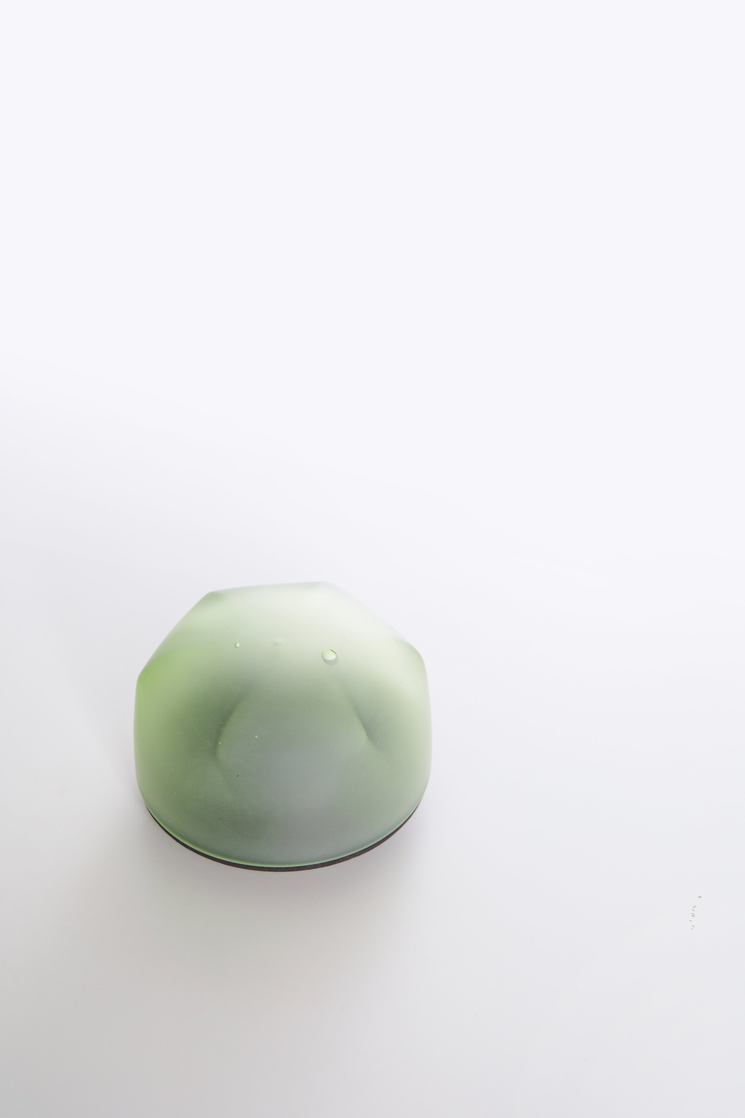 Green vase with water droplets on a white background.