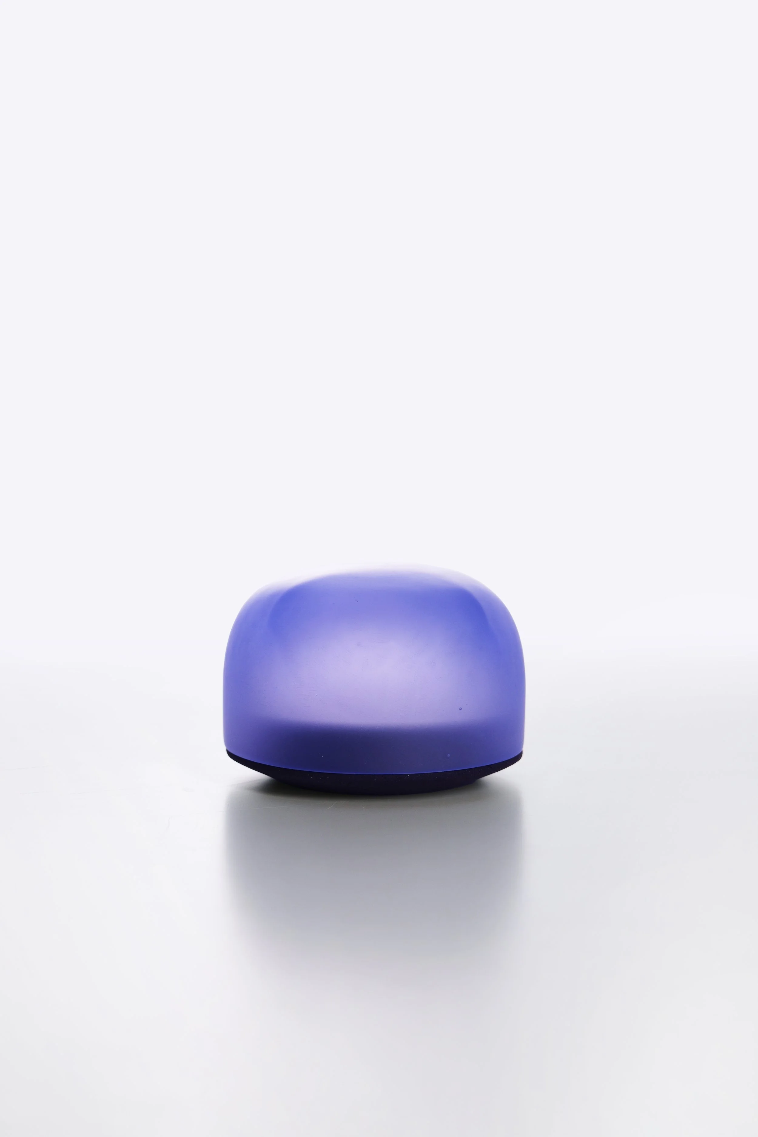 A small, rounded, purple and blue smart speaker with a black base, set against a white background.
