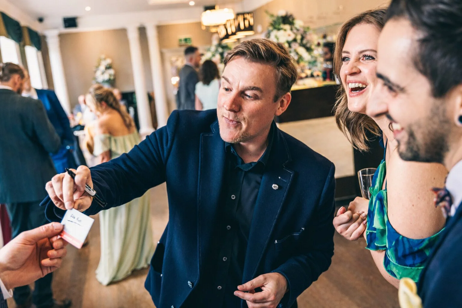 A group of people reacting in amazement to one of Looch's mix & mingle performances at a wedding.