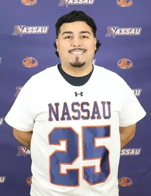 Young man wearing a white Nassau football jersey with the number 25, standing in front of a blue Nassau-themed backdrop.
