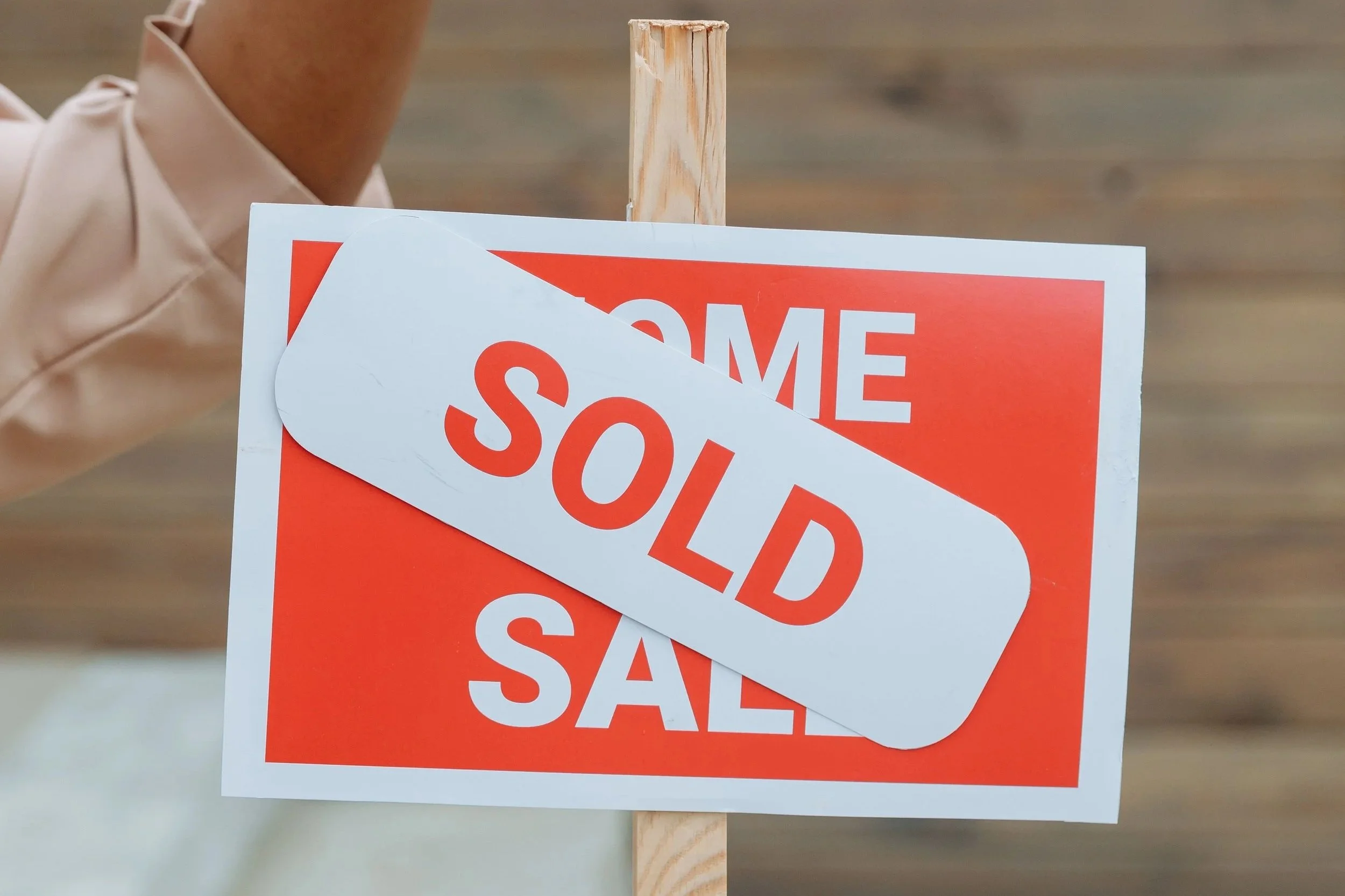 A "Sold" sign posted in front of a house, representing the property sale that starts a reverse 1031 exchange timeline.
