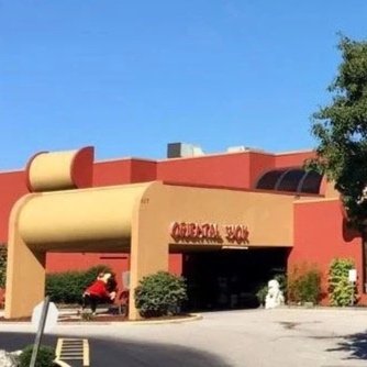 Exterior of a Cracker Barrel restaurant with a horse-drawn carriage in front.