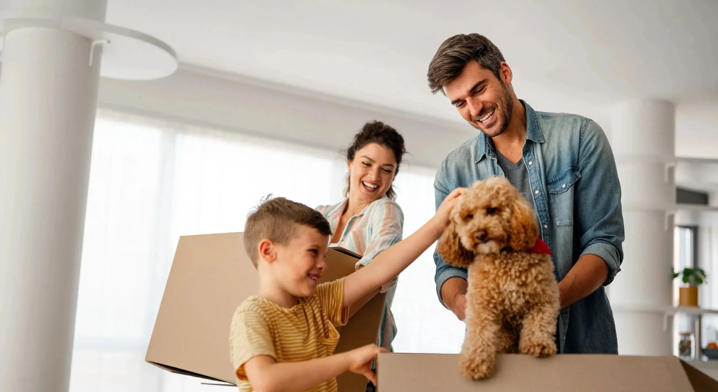 A happy family unboxing a puppy at home. The boy is petting the puppy, and the parents are smiling behind them.