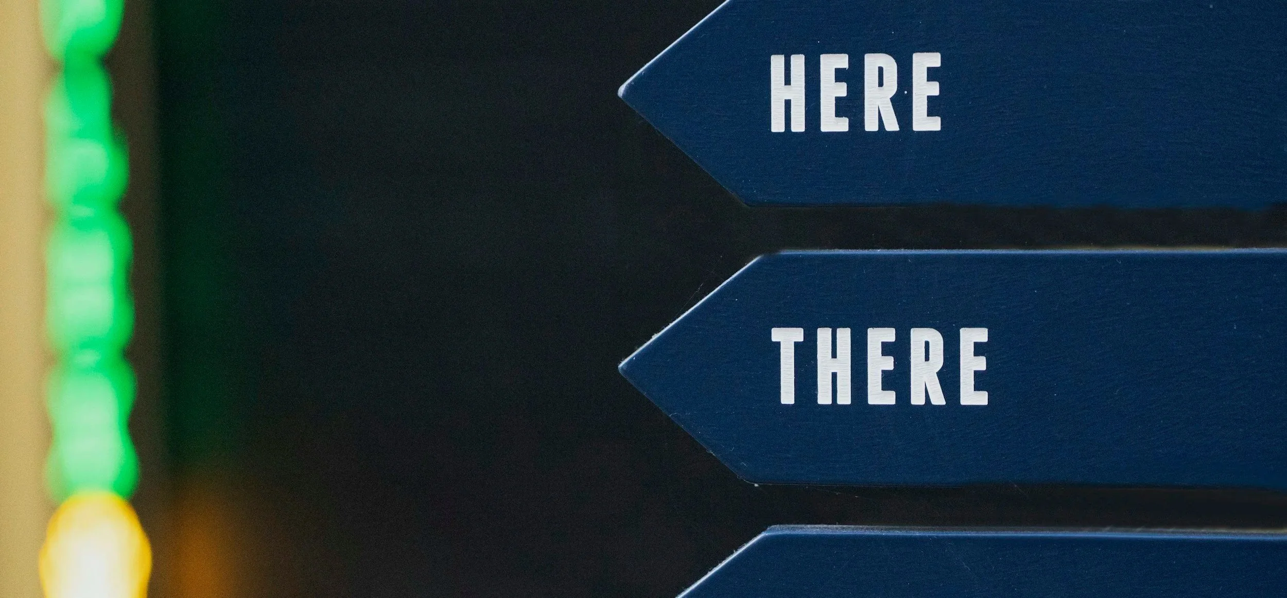 Blue directional signs with white text reading 'HERE' pointing in opposite directions.