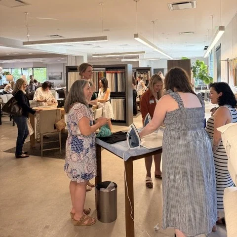 Women shopping and browsing fabric samples at an indoor store