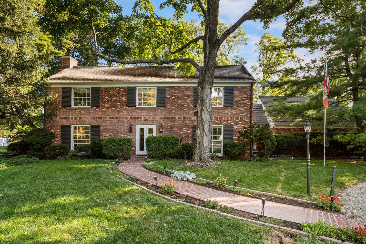 A picture of Trent Meacham's Real Estate listing of a two-story all brick home on a large lot in central Champaign near Champaign Country Club with well-maintained lawn.