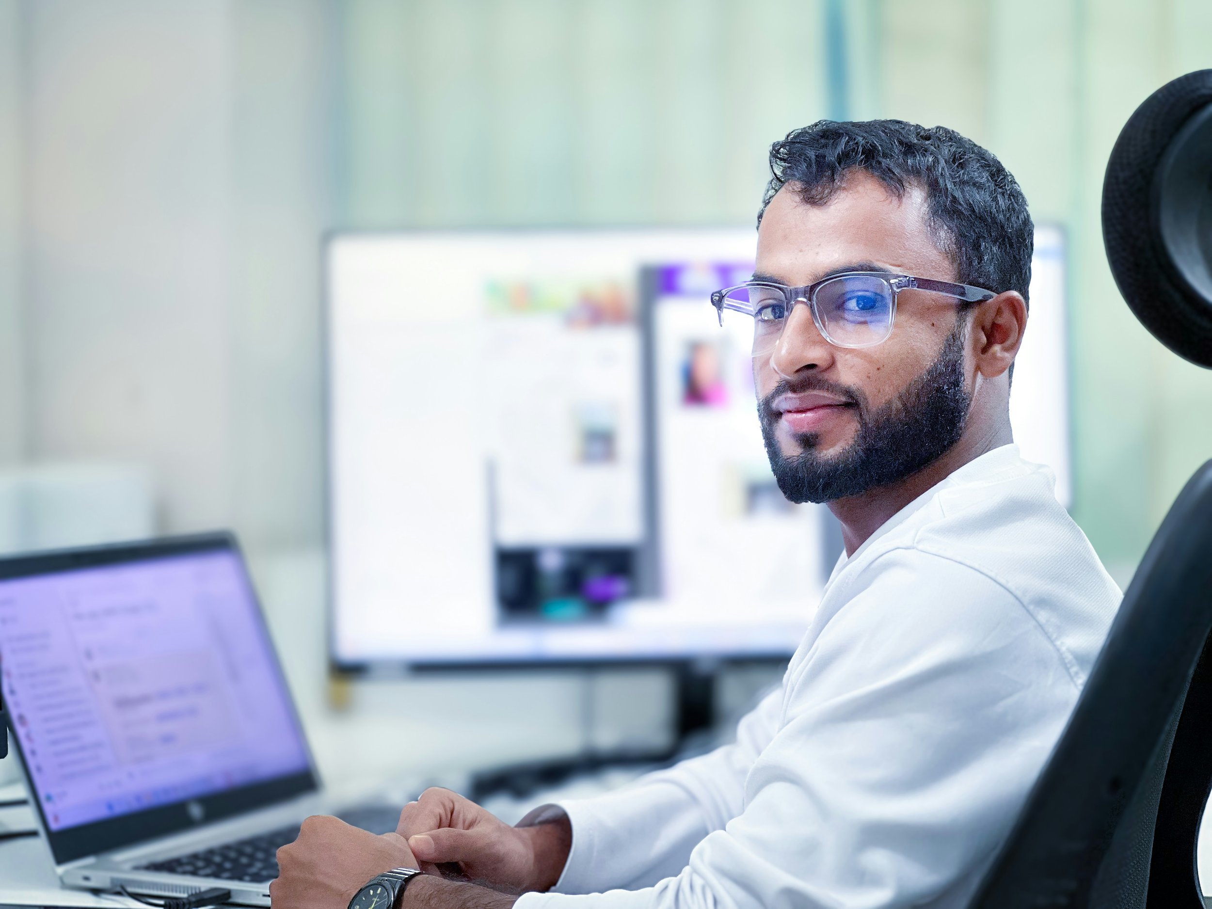 man in a research lab sitting at a computer