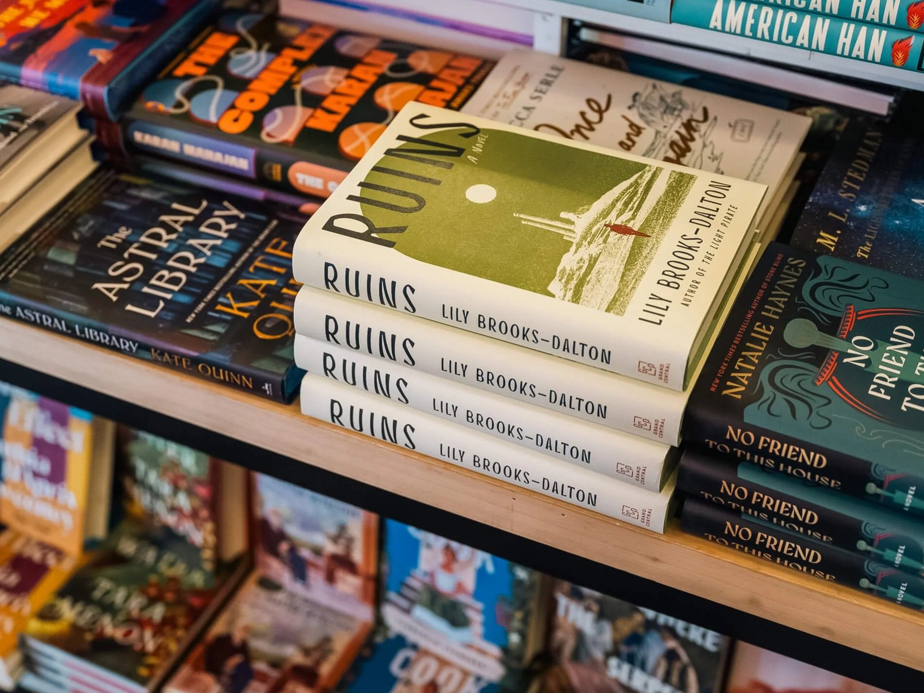 Stack of copies of Ruins by Lily Brooks-Dalton prominently displayed on a shelf at Paper Boat Booksellers, surrounded by other fiction titles