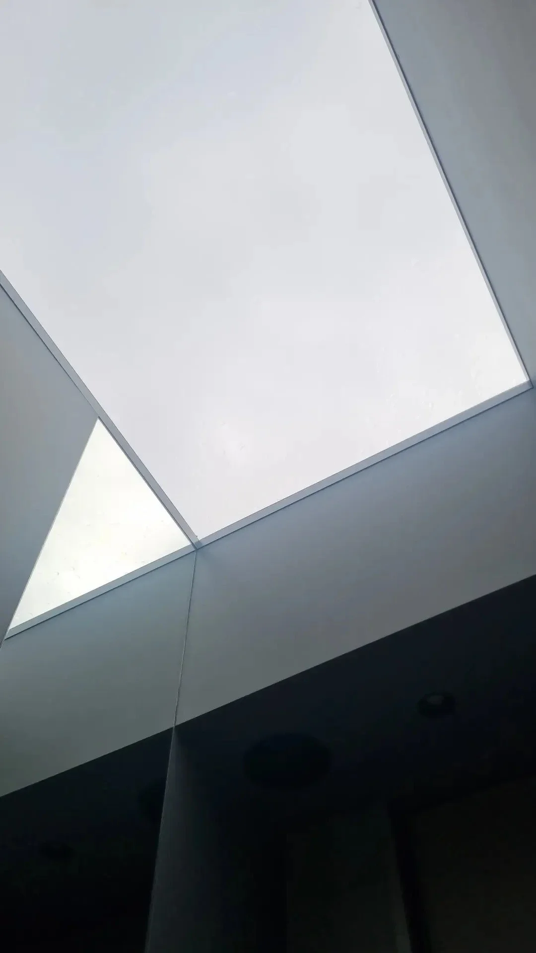 Ceiling with square recessed lights and geometric design elements.