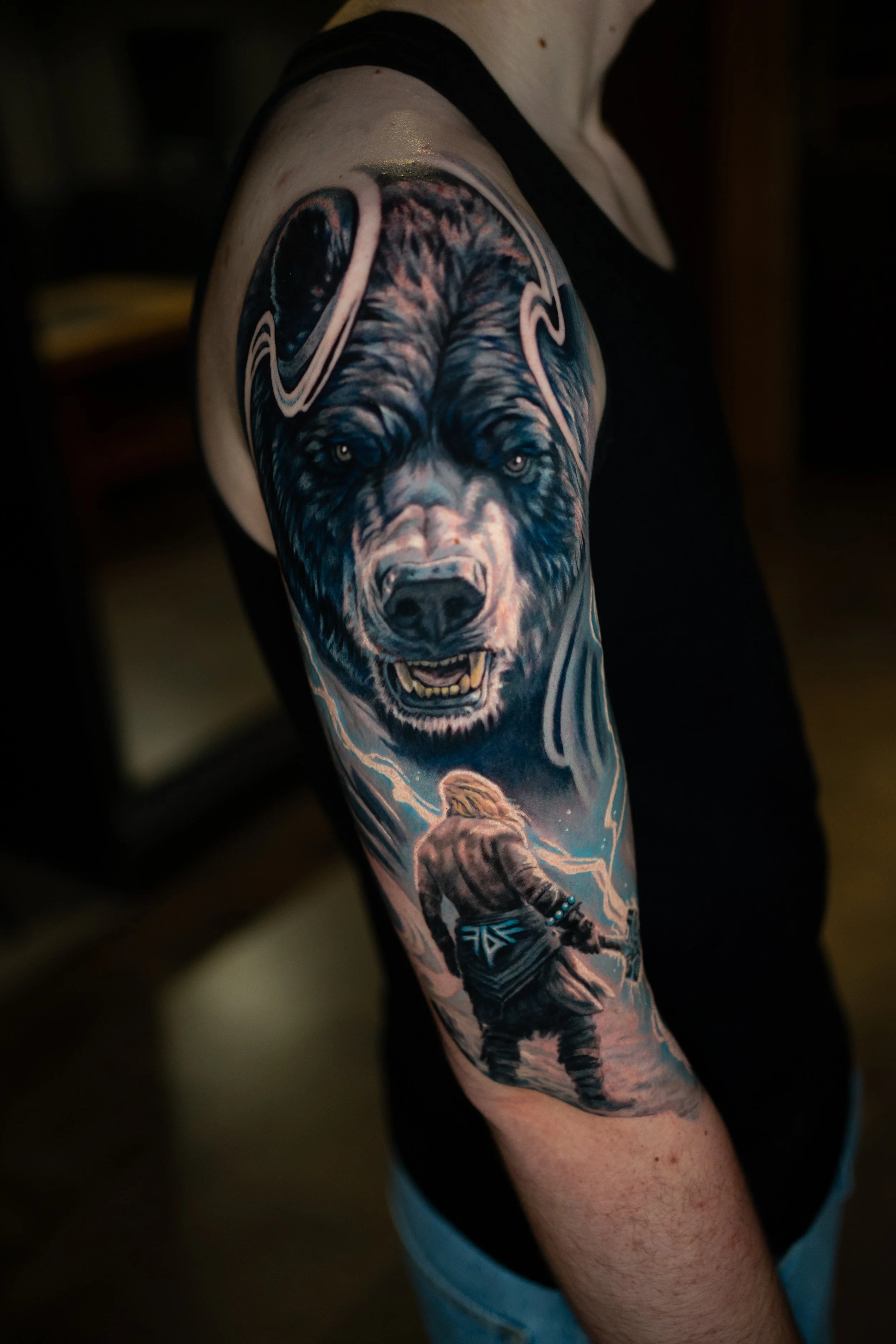 Tattoo eines Wolfes auf dem Oberarm einer Person.