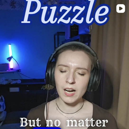 Artist sandra spirou singing a demo of "Puzzle", one of her original songs. The image shows blue background LED lights.