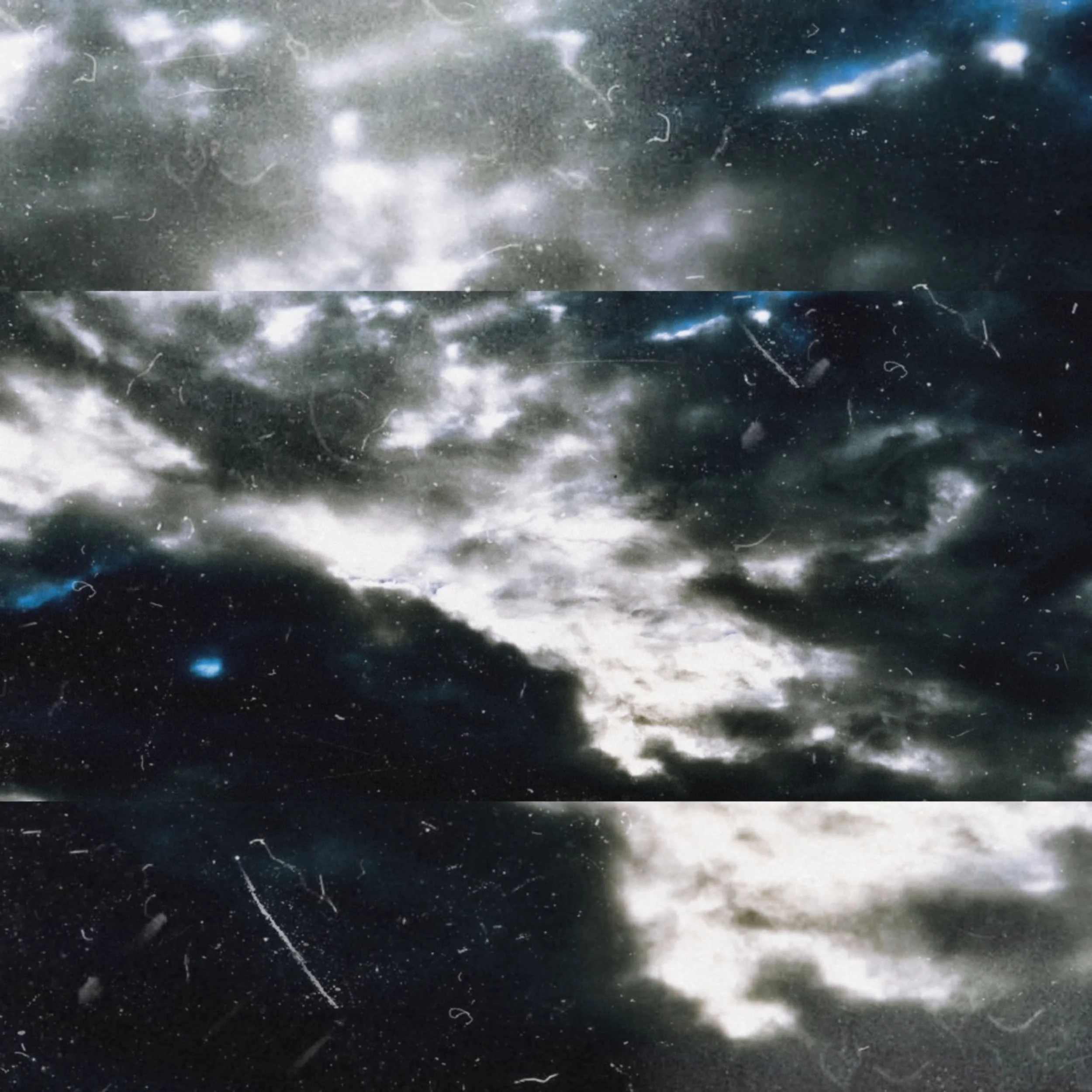 A textured photograph of white and dark grey clouds moving across a dark evening sky, styled with vintage dust and scratch effects.