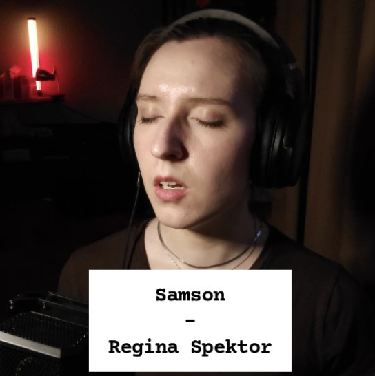artist sandra spirou singing a cover of the song Samson by Regina Spektor. The image shows dark but warm shades of brown and red.