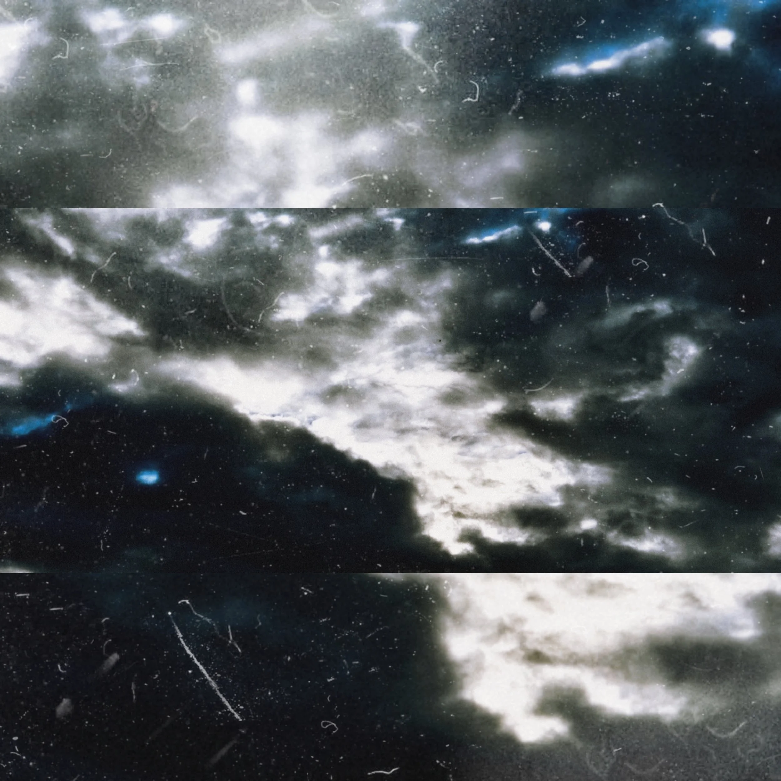 An atmospheric view of a sky with clouds in highly contrasted shades of grey with dust effects.