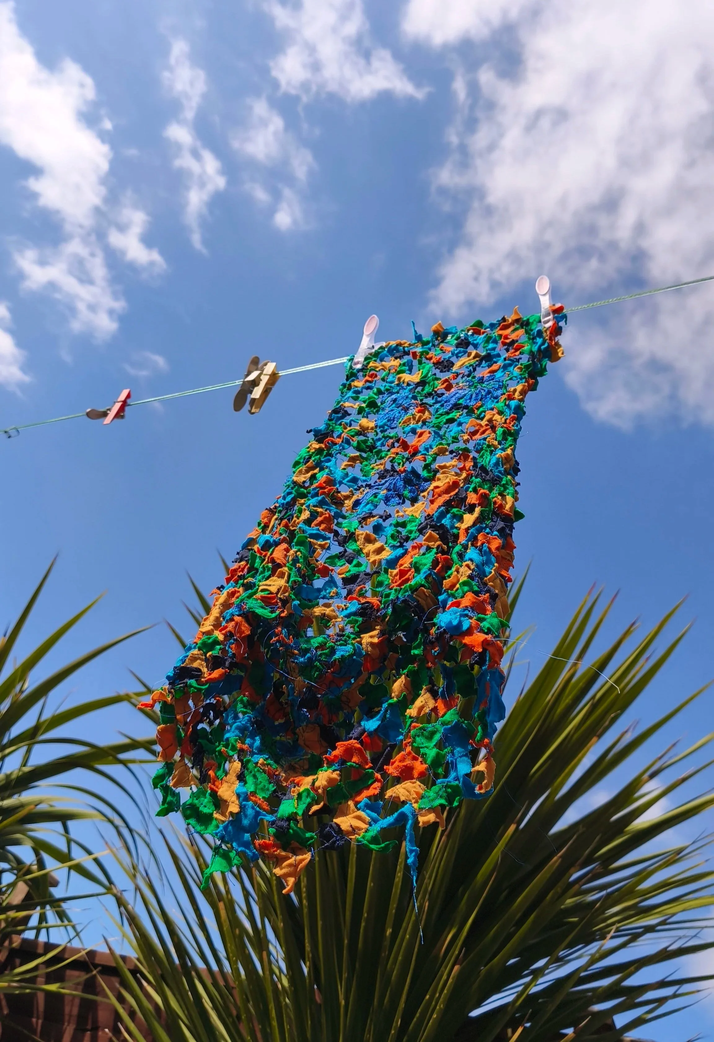 blue sky with clouds and shredded fabric on a washing line