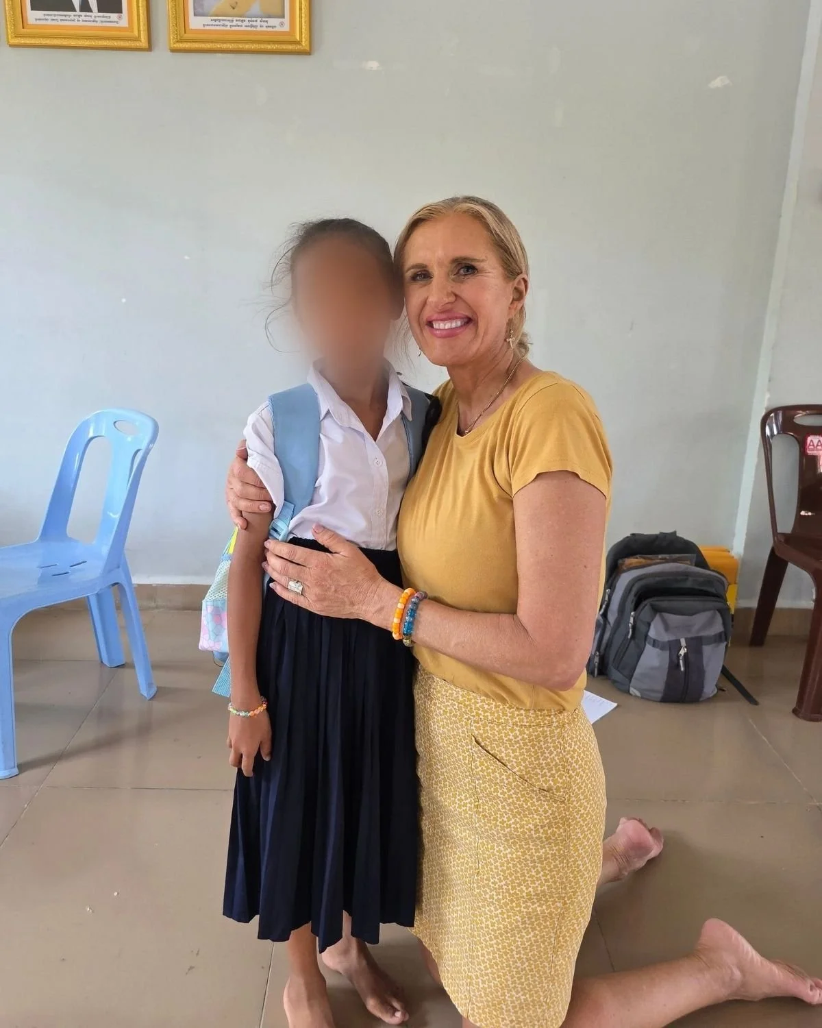 Ruth in a yellow dress hugging her heart daughter