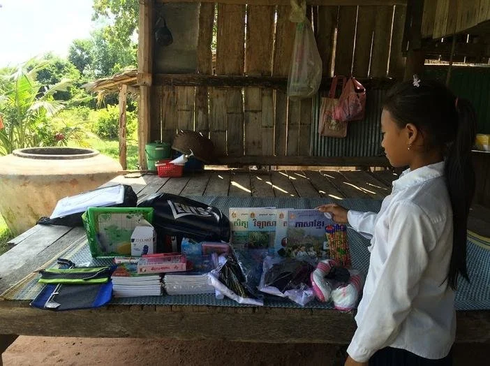 A heart daughter standing in front of a table of donations