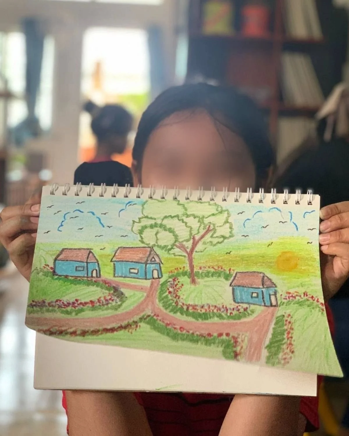 Heart Daughter holding up one of her drawings
