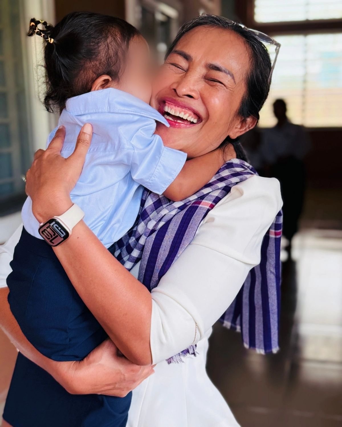 Somaly with a young baby hugging and smiling
