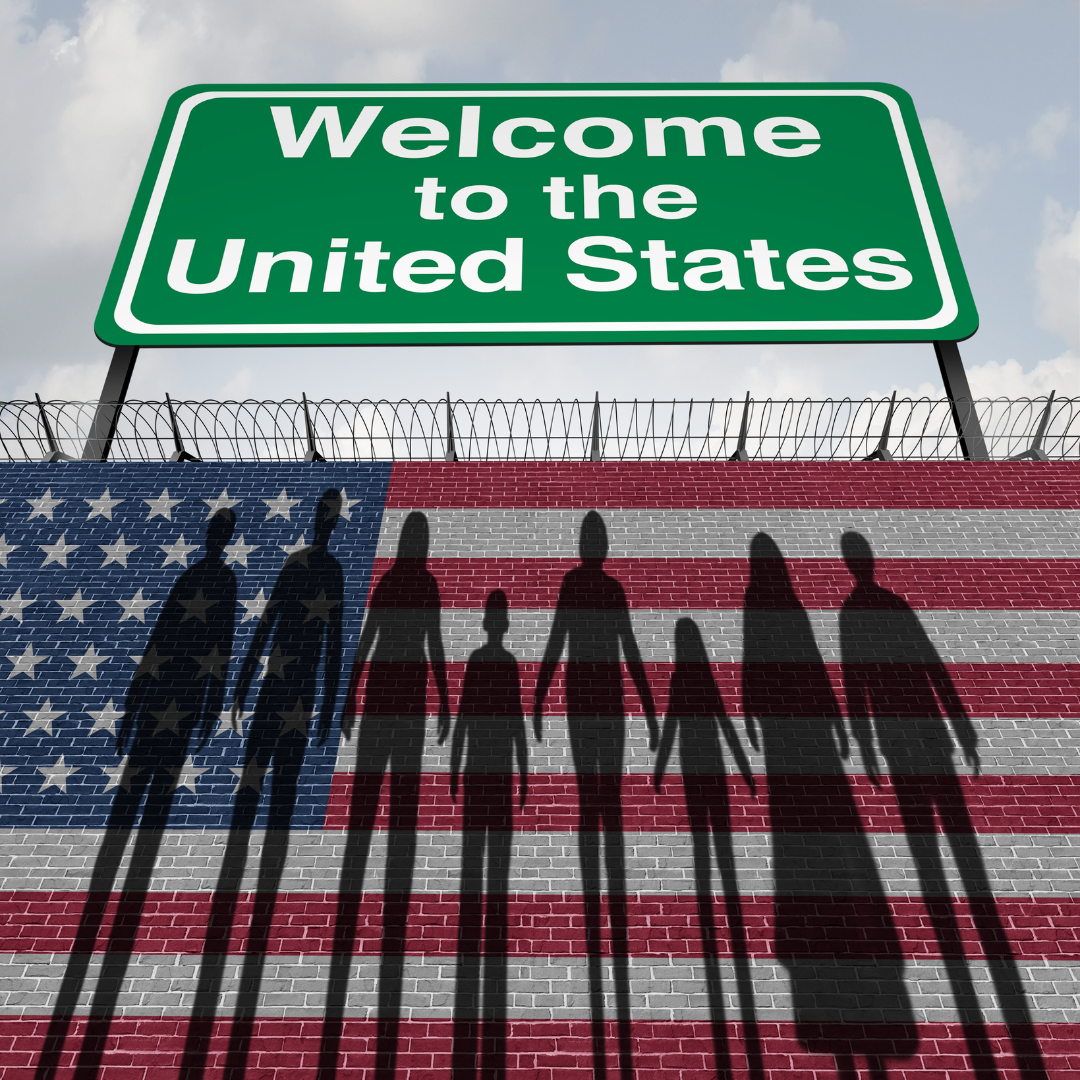 A large green sign that reads 'Welcome to the United States' above a brick wall painted with the American flag, with shadows of a family of seven holding hands cast onto the flag.