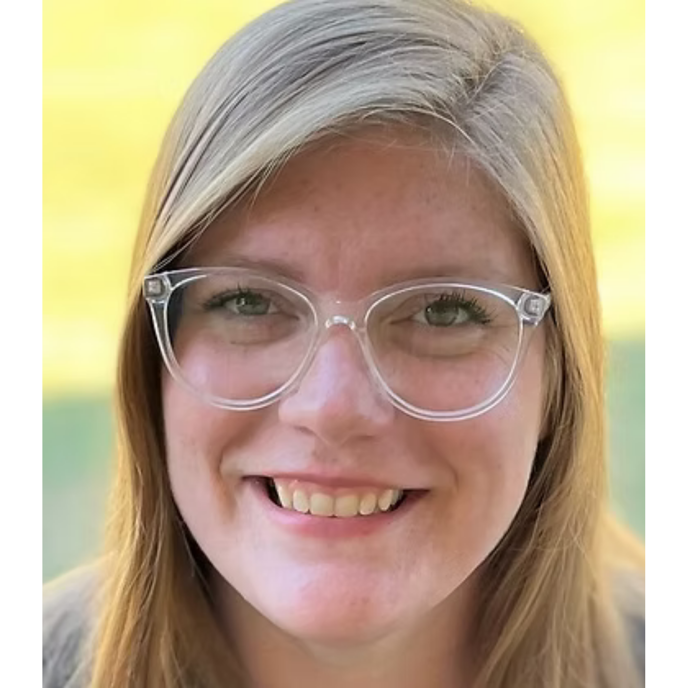 Katelyn of Huntsville Behavior Associates with long blonde hair and clear glasses, smiling outdoors with a softly blurred background.